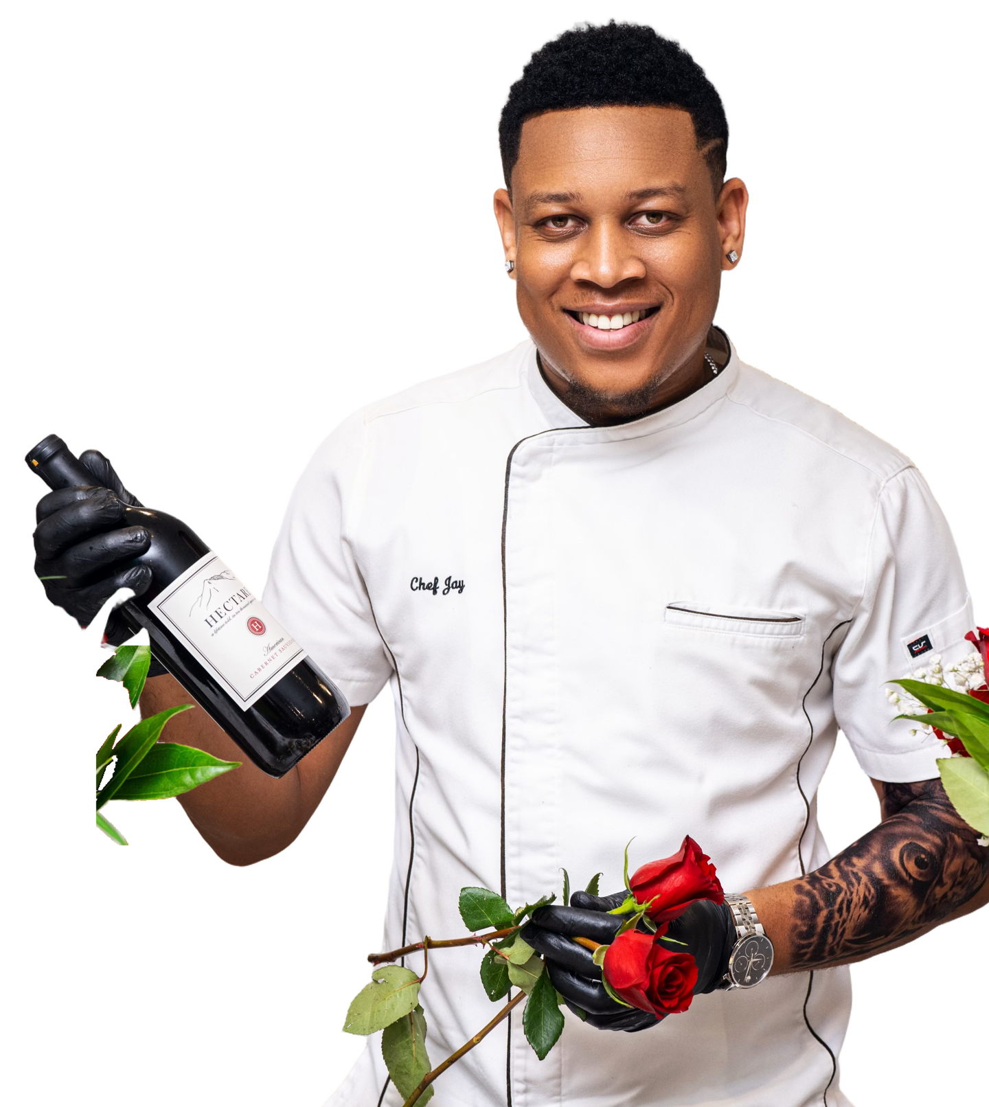 Chef Jay smiling in his white chef jacket, holding a wine bottle and roses